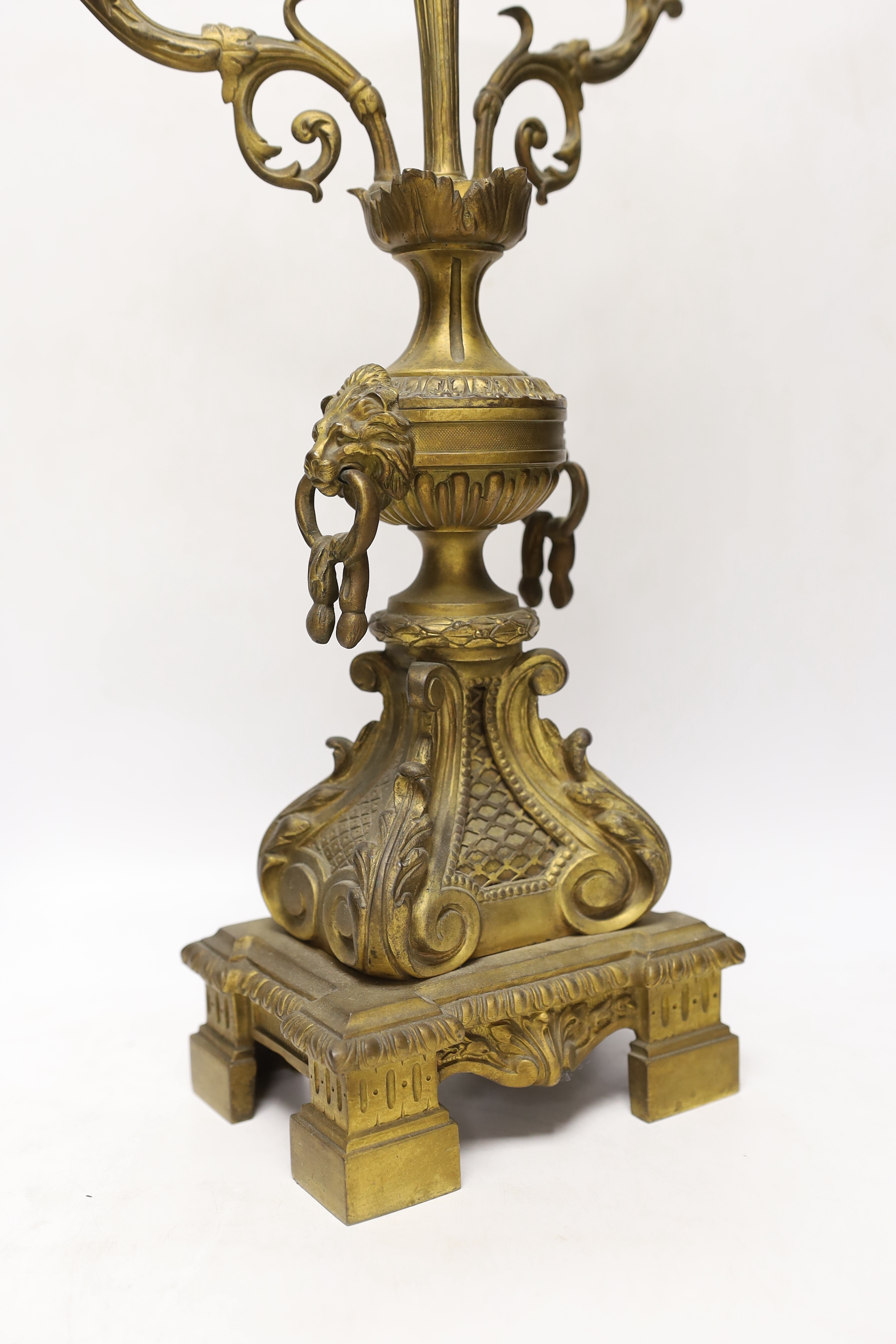 A pair of brass lustre drop candlesticks, lamp base and three branch candelabra, 59cm high